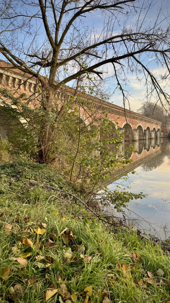 Aquaduct with arches reflected in a calm river beneath