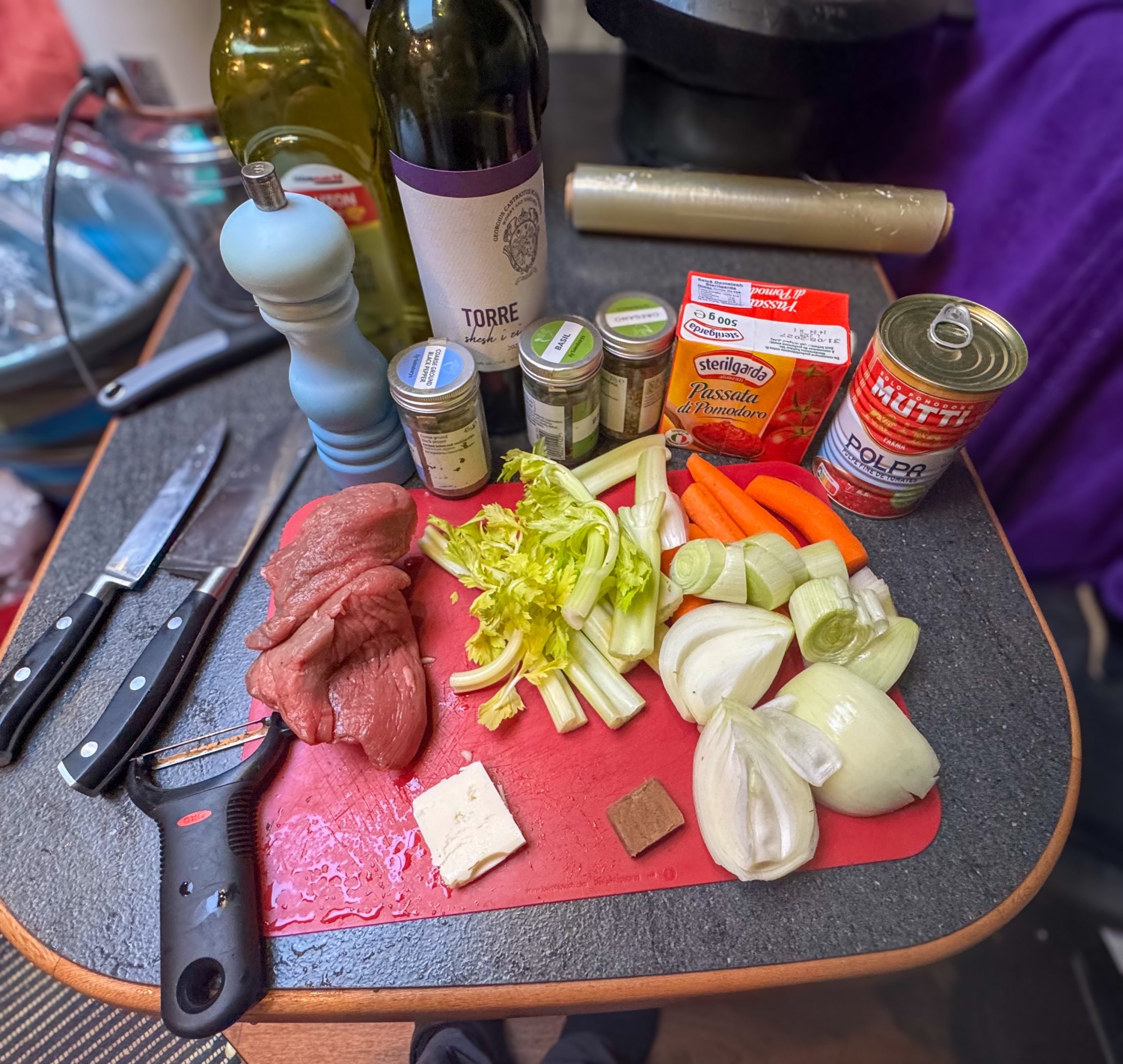 Ingredients for beef ragu laid out on a chopping board